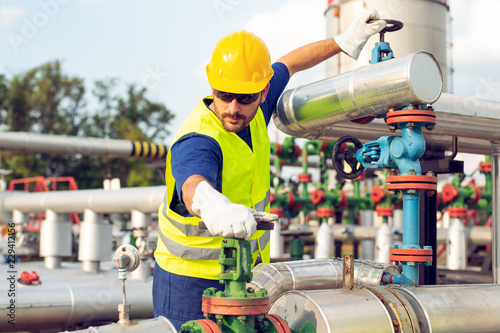 Photography Oil worker closes the valve on the oil pipeline