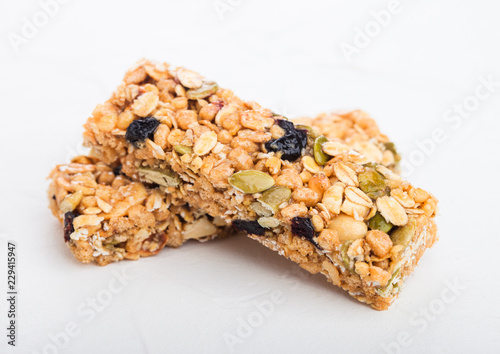 Homemade organic granola cereal bars with nuts and dried fruit on white background