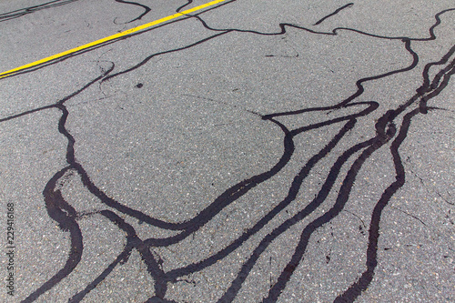 asphalt road with filled cracks. background of the fixed road