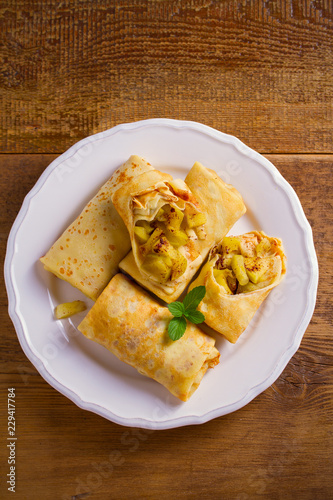 Delicious homemade crepes filled with apples and cinnamon. overhead, vertical