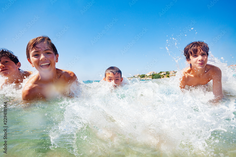 Joyful boys having fun while swimming in the sea Joyful boys having fun while swimming in the sea