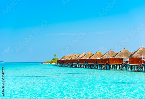 Water villa in a row by the seashore, Maldives. Copy space for text. © ggfoto