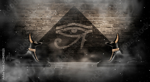 Anubis of Ancient Egypt (God of Death). Dark abstract Egyptian background, dark room with smoke, pyramid, rays of light.