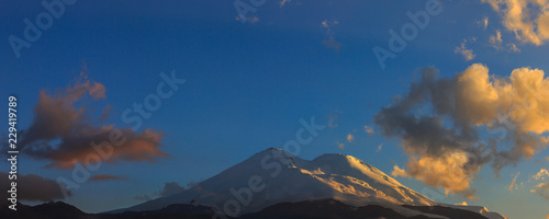 Mount Elbrus during sunset in the rays of the sun. Panoramic view of the mountain range in the North Caucasus in Russia.