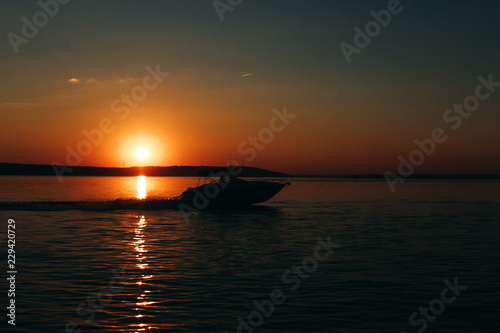 Boat on the lake during the orange sunset