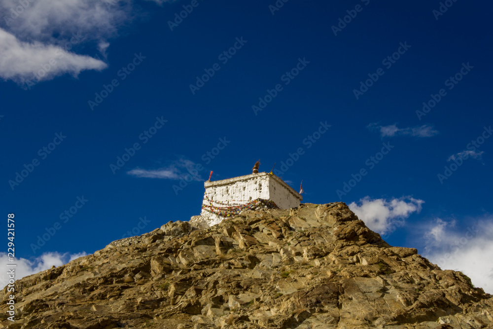 Tibetan temple on a rock under a dark blue sky