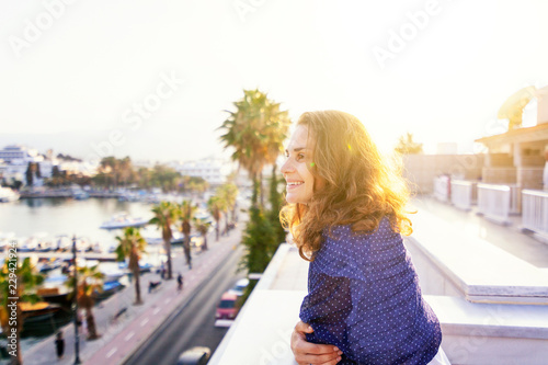 Portrait of a beautiful happy smiling young woman with beautiful lush curly hair in the sun