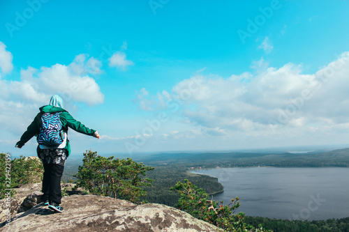 Muslim girl on mountain looks at the lake and forest