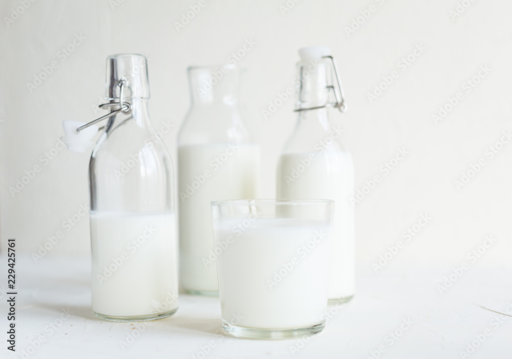 Milk in bottles on white background, kitchen Milk in bottles on white background, kitchen