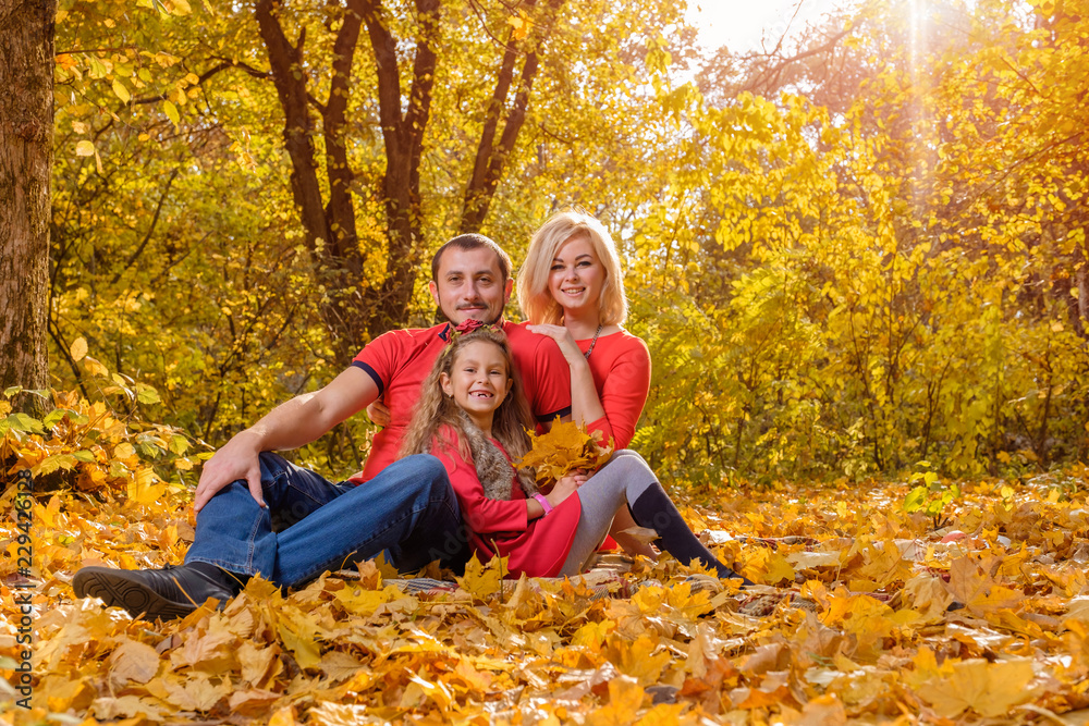 Beautiful young family resting in sunny warm autumn day Beautiful young family resting in sunny warm autumn day