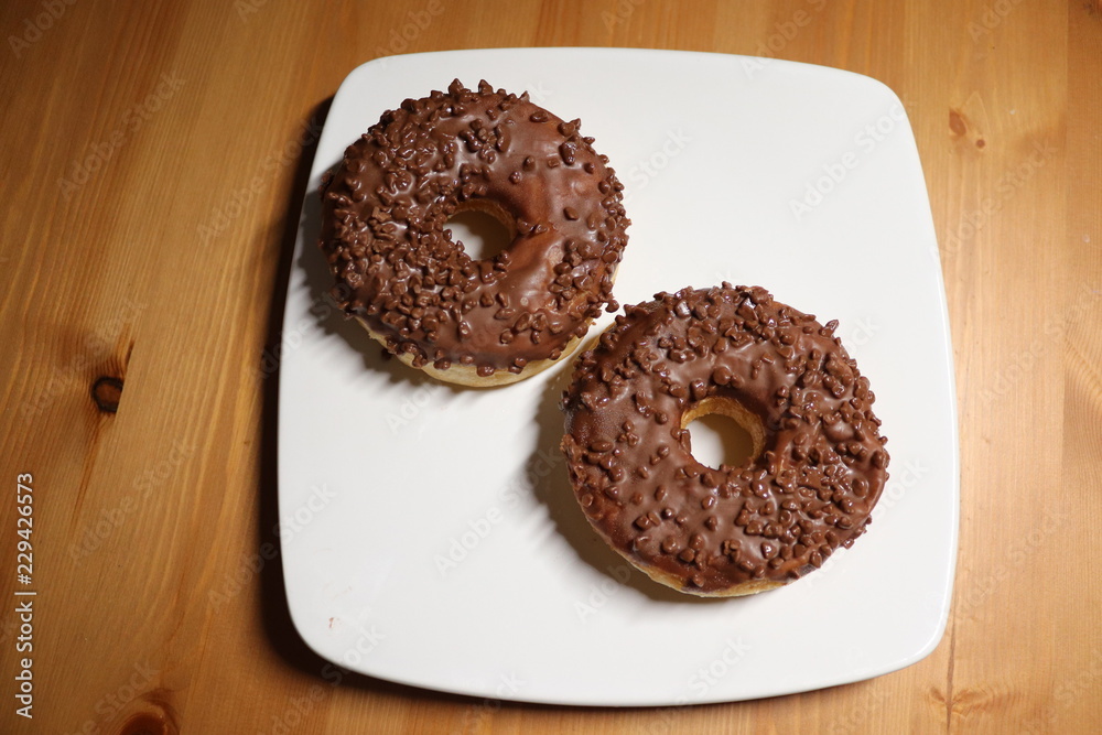 ring chocolate covered doughnuts on a white plate ring chocolate covered doughnuts on a white plate