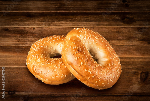 Fresh sesame seed bagel bread  isolated on a vintage wooden table in background.