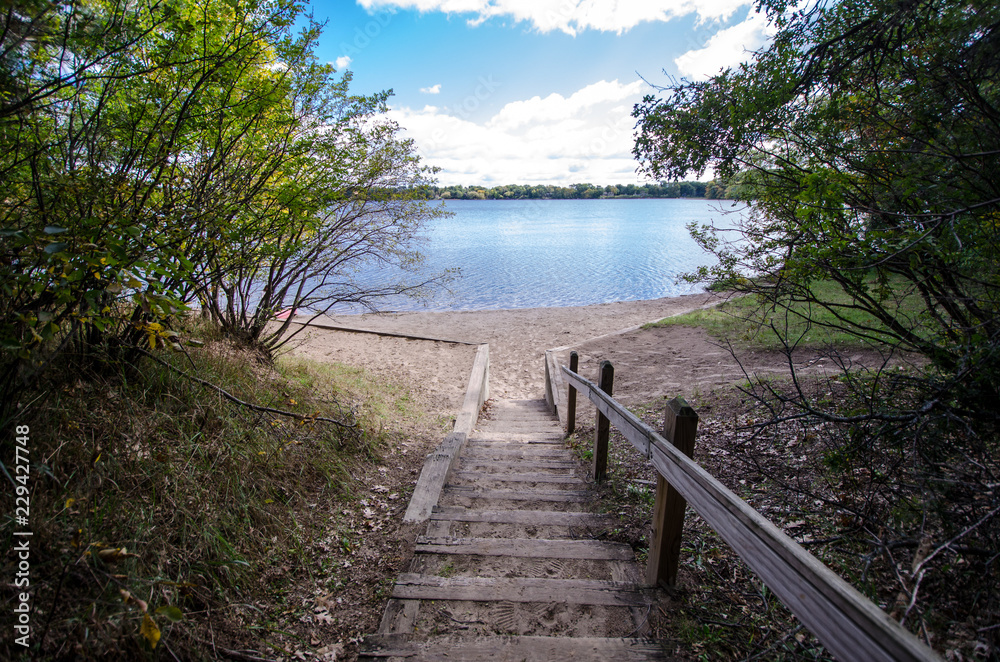 Fototapeta premium Stairs and steps walkway path down to Lake Ann in Zimmerman, Minnesota on a summer day