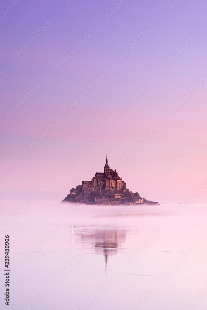 old castle in foggy morning between sky and water in France