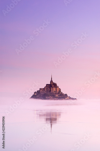 Fotografiet old castle in foggy morning between sky and water in France