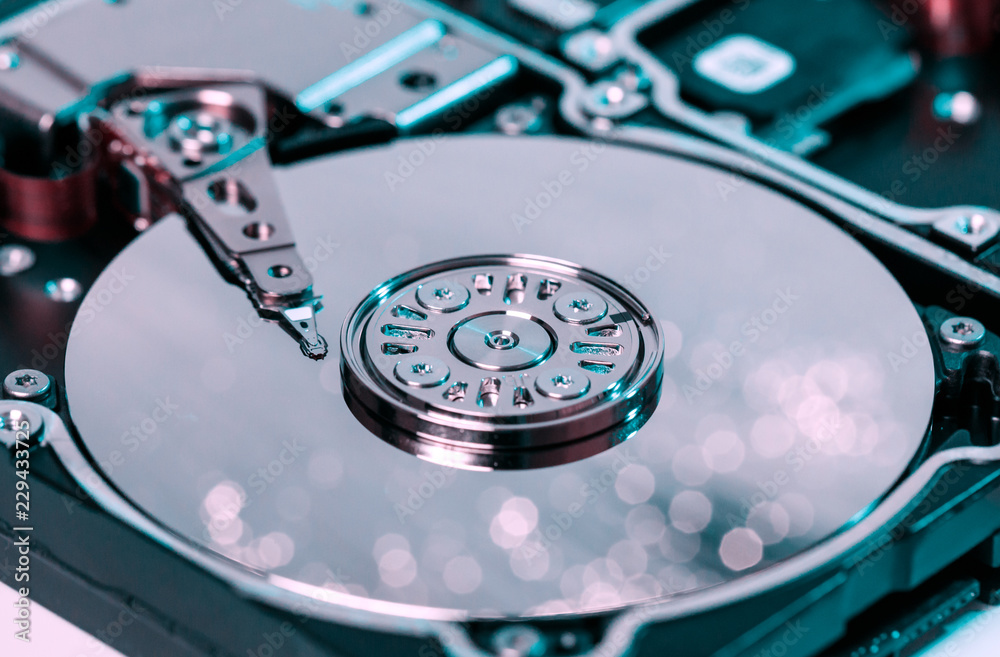 disassembled hard disk, magnetic heads and polished plates illuminated optical fiber with blurred lights disassembled hard disk, magnetic heads and polished plates illuminated optical fiber with blurred lights