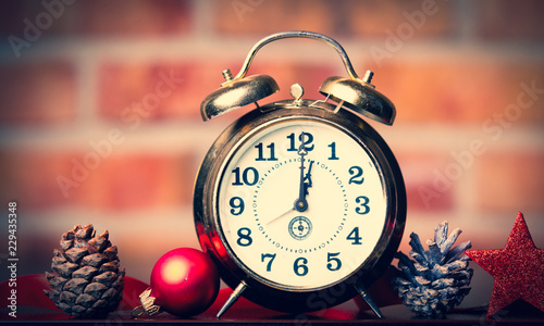Christmas clock and ribbon with baubles on brick wall background