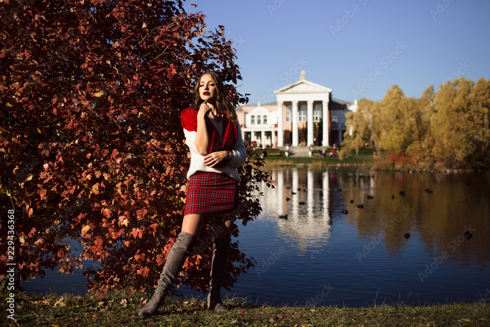 Obraz premium Pretty woman is wearing fashion clothes in autumn park
