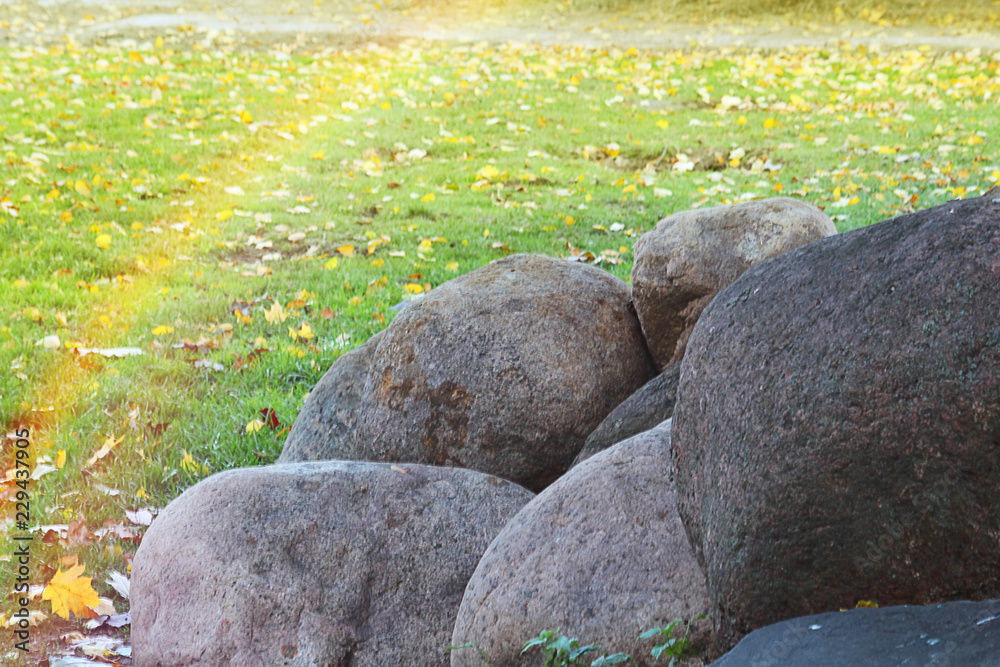 Decorative landscape at sunset. Natural stone in landscape design. Rainbow. Selective focus, close-up, side view, copy space, layout. Decorative landscape at sunset. Natural stone in landscape design. Rainbow. Selective focus, close-up, side view, copy space, layout.