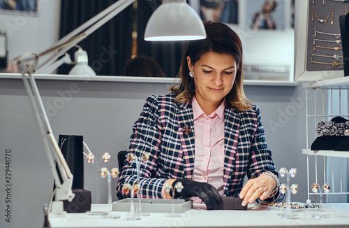 Wallpaper Mural Woman seller packs precious earrings in a box for her client in a luxury jewelry store. Torontodigital.ca
