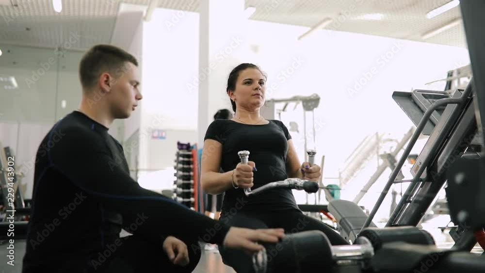 Personal fitness trainer helping make exercice for beginner woman in gym