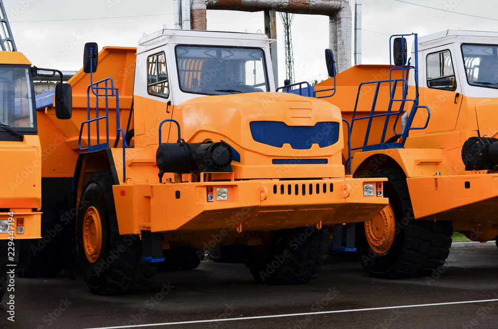Low yellow dump truck for transportation of rock mass and minerals in underground workings, tunnels and other cramped conditions. Special equipment. Mining, career