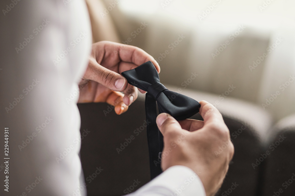businessman putting on  bow tie,man butterfly clothes,groom getting ready in the morning before wedding ceremony