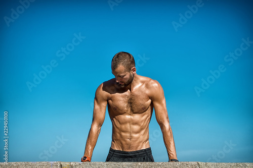 Guy motivated workout. Sportsman improves his strength by push up exercise. Push ups challenge. Improve endurance by push ups. Man doing push ups outdoor blue sky background