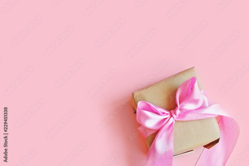 Wrapped gift box and photo tied with a satin pink ribbon on top. Free space for text. Flat lay photo Wrapped gift box and photo tied with a satin pink ribbon on top. Free space for text. Flat lay photo