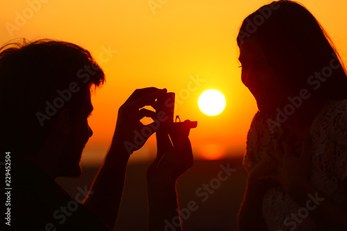 Marriage proposal at sunset with sun in background