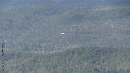 Hanggliders launching from a perch or towed by small motorized air craft. Hanggliders flying