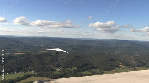 Hanggliders launching from a perch or towed by small motorized air craft. Hanggliders flying