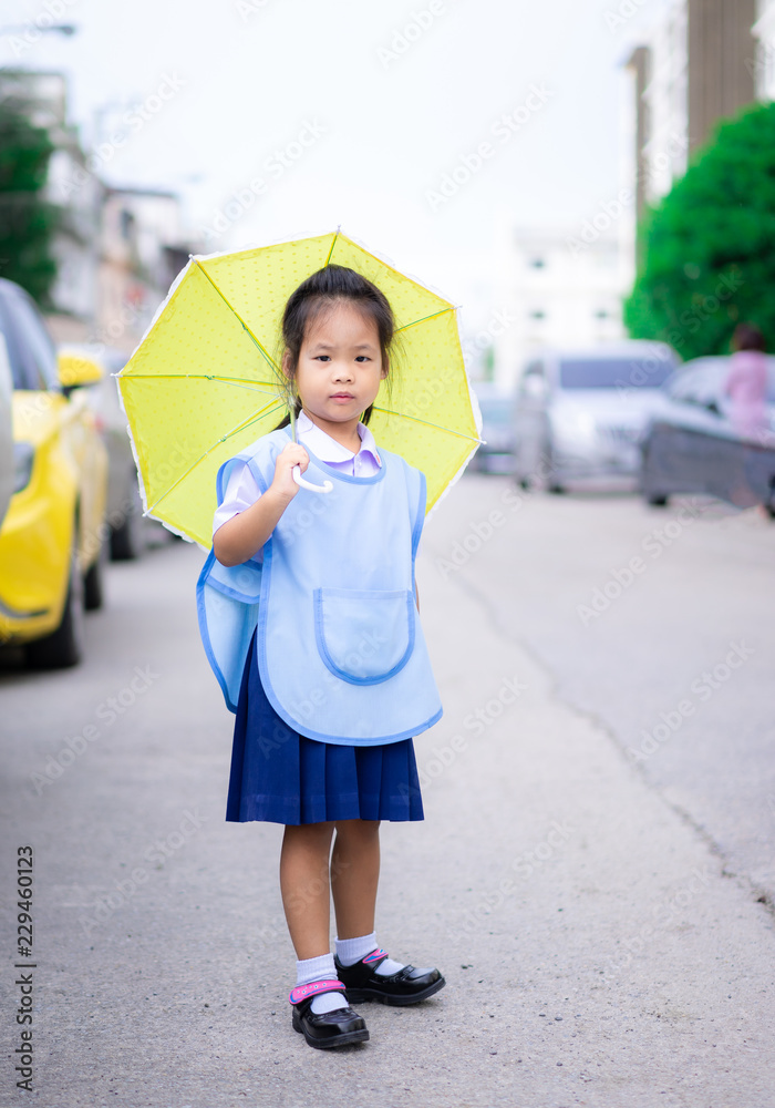 little girl with umbrella standing in car park ready back to school in ...