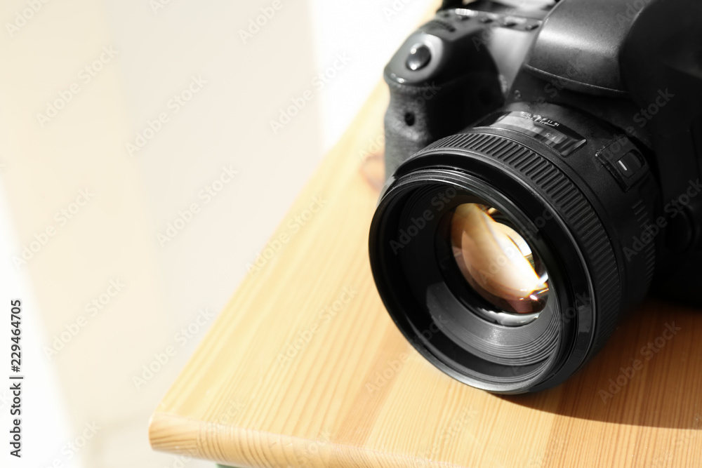 Professional camera on wooden table, space for text. Photographer's equipment