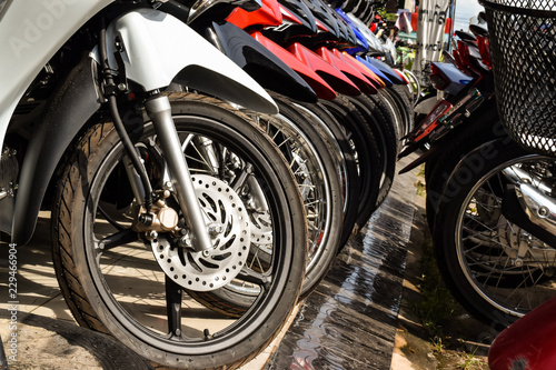 Motorcycles standing in the row. Row of many motorcycle wheel at the Showroom for sale.