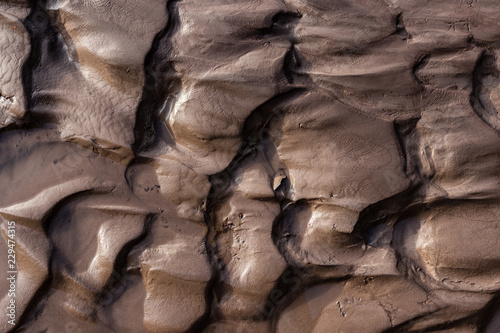 Glacial riverbank shore with wet black silt sand mud