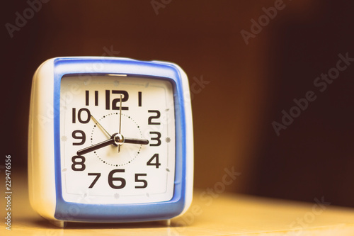 Blue and white square analog clock. Space for text.