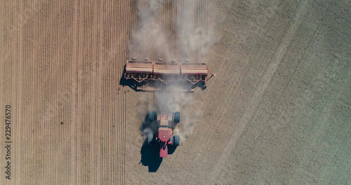 Aerial Photography of a Farmer Plowing a Dusty Field 