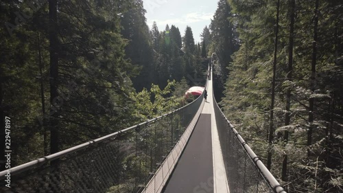 Woman walking on empty suspension bridge with Canadian flag photo