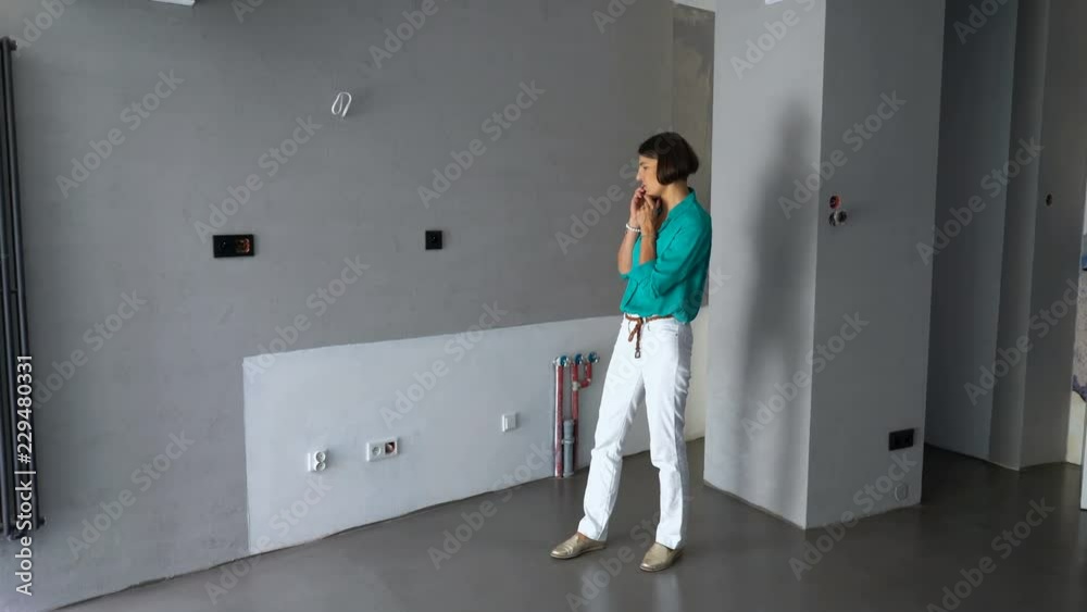 Young woman architect talking on cellphone at new home Young woman architect talking on cellphone at new home