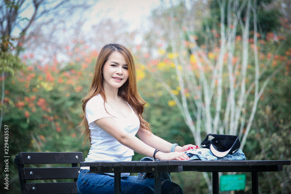 Portrait Asian woman wearing a T-shirt and jeans. Are happy in the public park