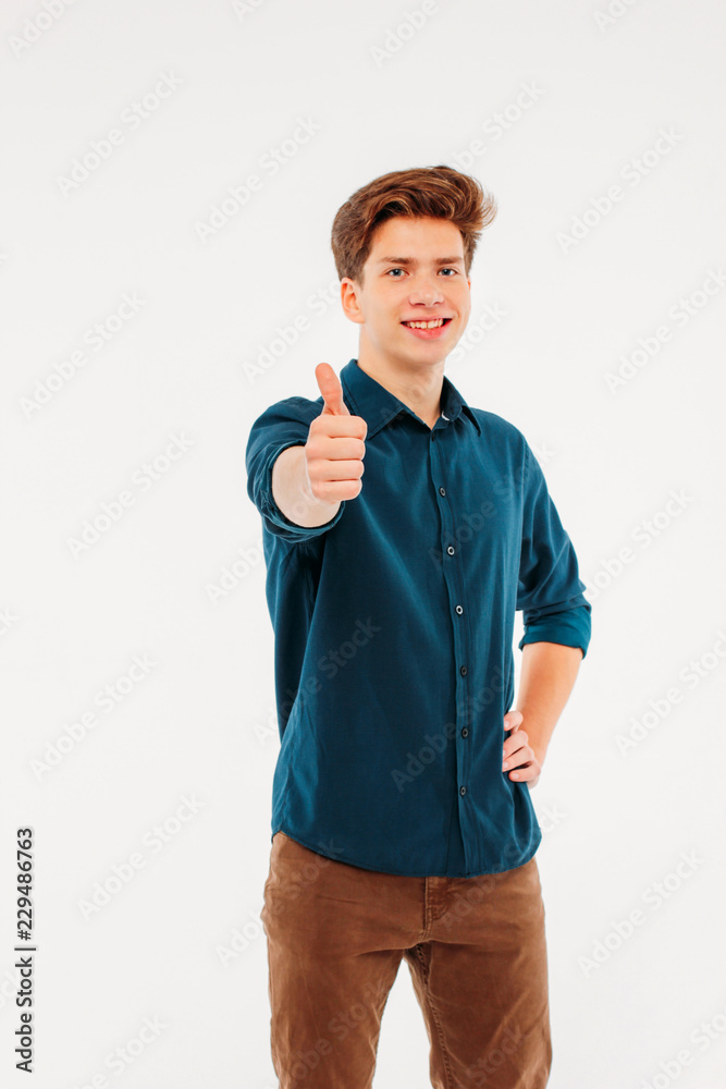 Attractive smiling boy 18 years old student showing thumbs up on Attractive smiling boy 18 years old student showing thumbs up on