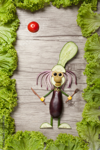 Vegetable cook on wooden board with frame made of salad
