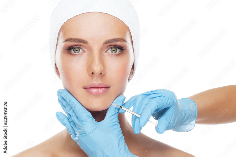 Doctor injecting in a beautiful face of a young woman. Plastic surgery concept. Doctor injecting in a beautiful face of a young woman. Plastic surgery concept.