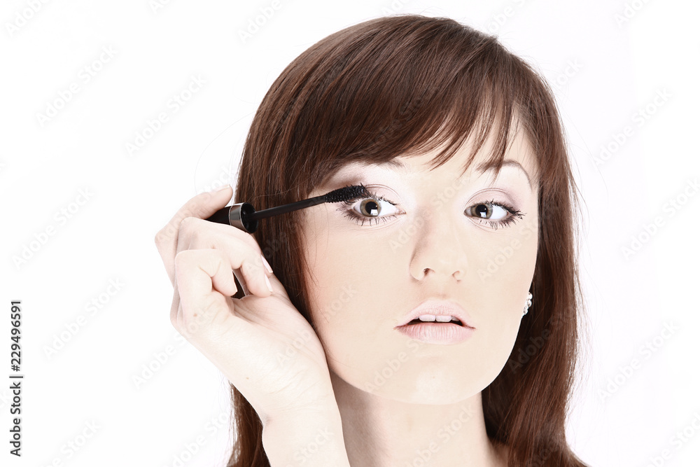 Beautiful young woman applying cosmetic paint brush