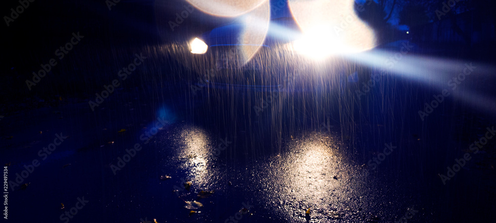 Raindrops on car headlights. Autumn rains, night view. Raindrops on car headlights. Autumn rains, night view.