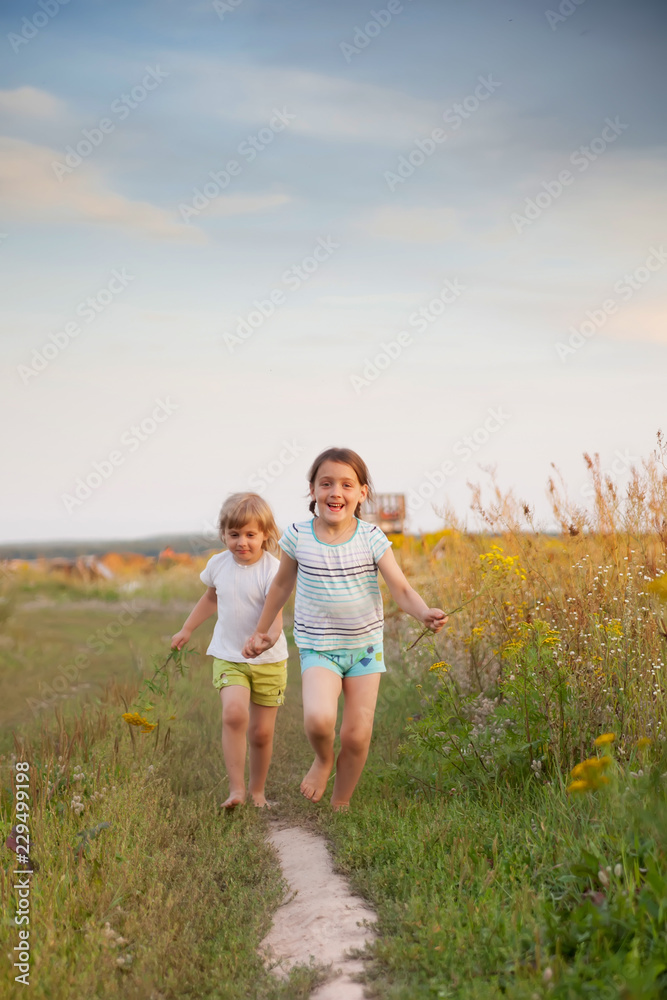  barefoot children on summer meadow.