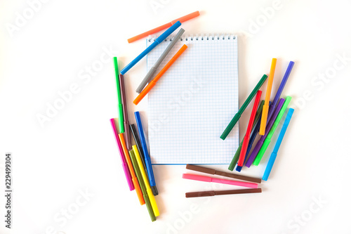 Multicolored felt pens with notebook isolated on white background. Recreation concept drawing