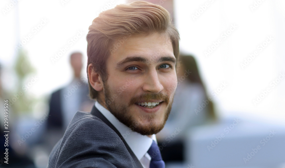 Successful business man standing with his staff in background at Successful business man standing with his staff in background at