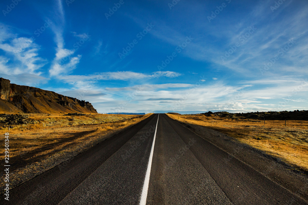 Road through iceland landscape. Road and car travel scenic and sunset.Road travel concept.Car travel adventure